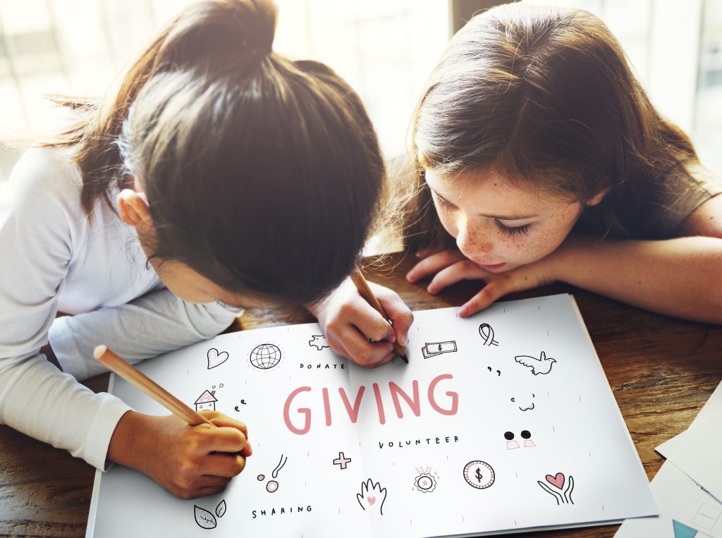 Dublin Community Foundation - two children drawing on a paper about giving and community